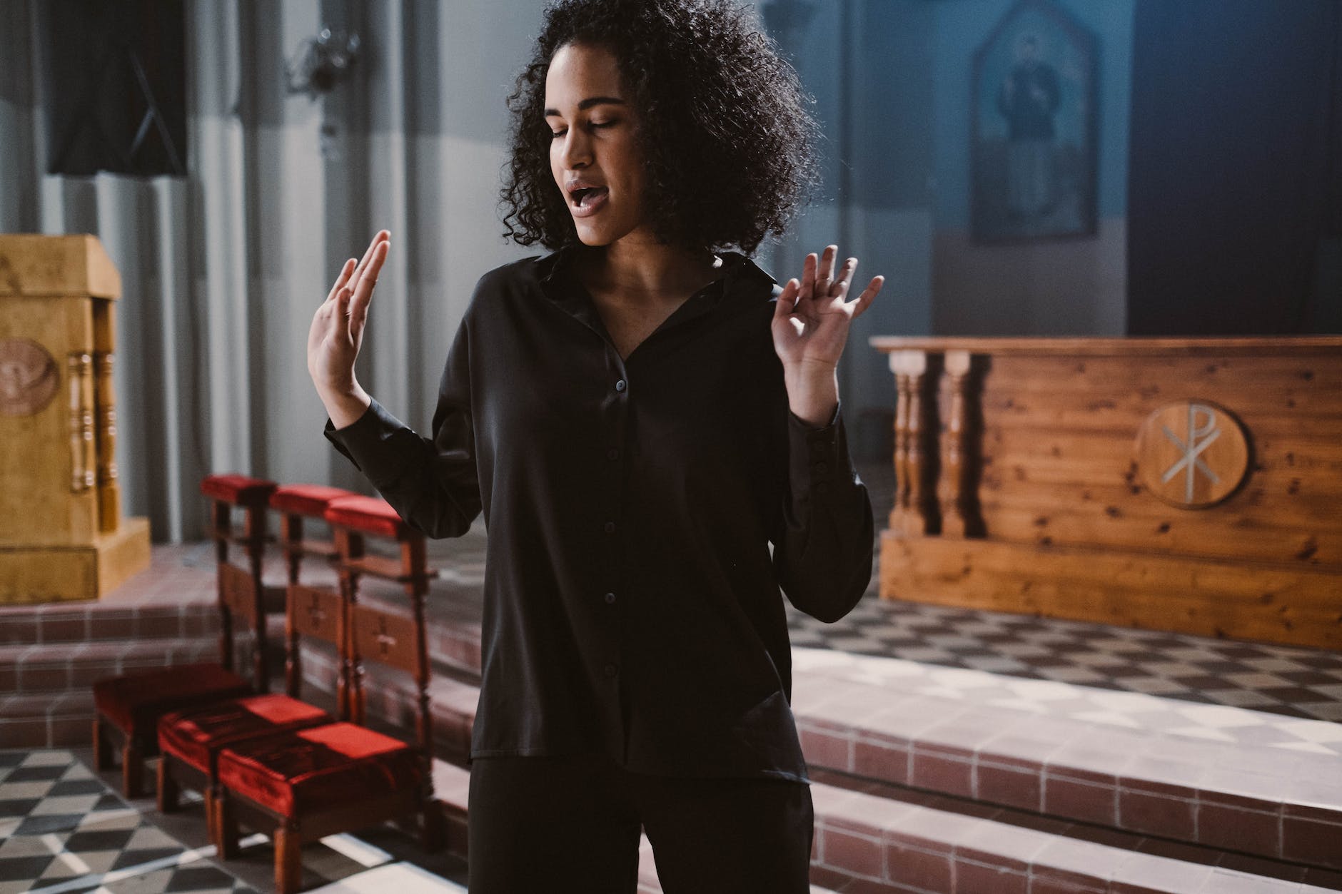 woman in black long sleeves standing near the altar