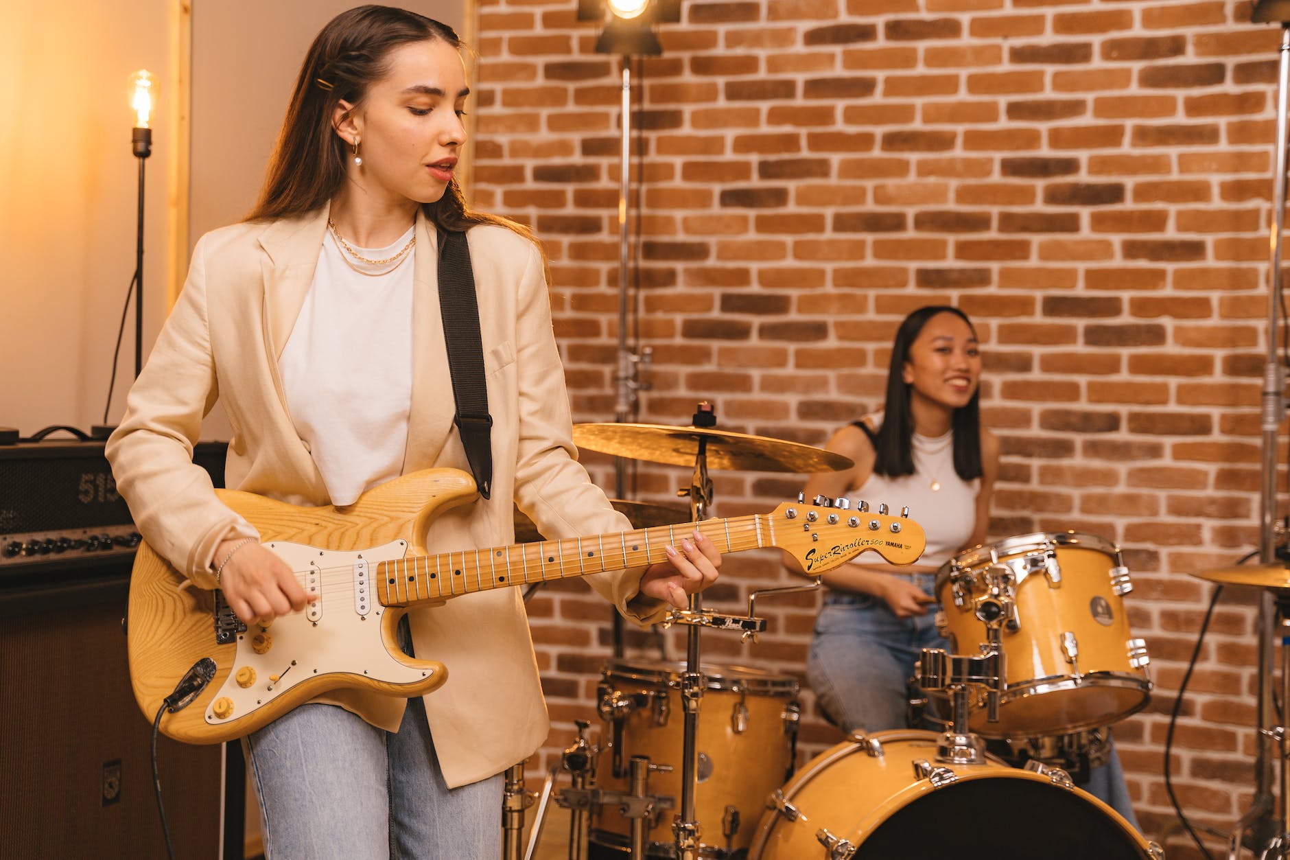 woman playing guitar and woman playing drums